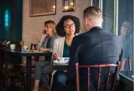 man wearing suit jacket sitting on chair in front of woman wearing eyeglasses